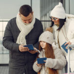 A family standing outdoors with luggage, preparing for their international travel journey. Ideal for tourists seeking travel services and visa assistance for a smooth vacation experience.